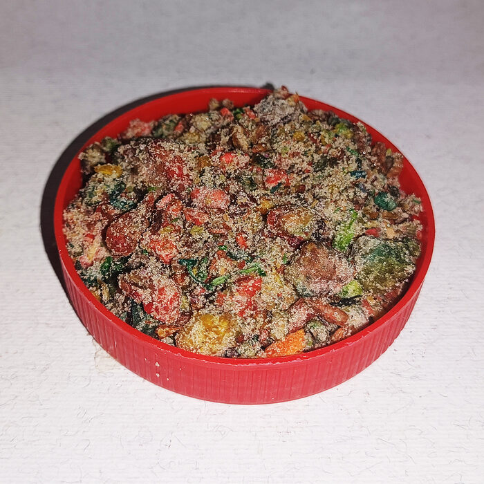 Vibrant Moroccan colored incense bokhor mix of red, green, yellow and brown botanical resins in a round red container on a white surface - Variation