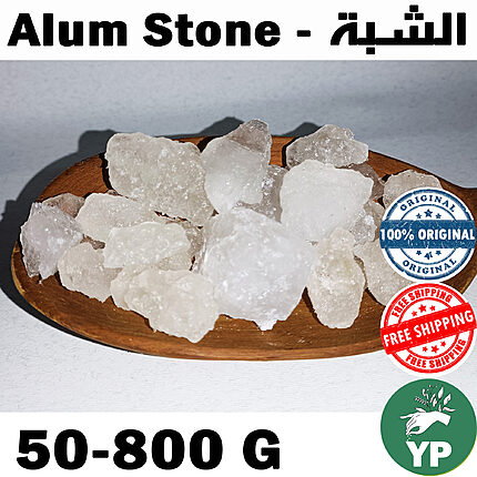 Raw white translucent alum stone crystals piled on a round wooden plate against a light grey background