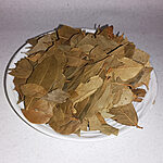 Whole dried golden-brown Moroccan bay leaves (Laurus nobilis) piled on a white ceramic plate, showing natural texture and authentic quality - Variation