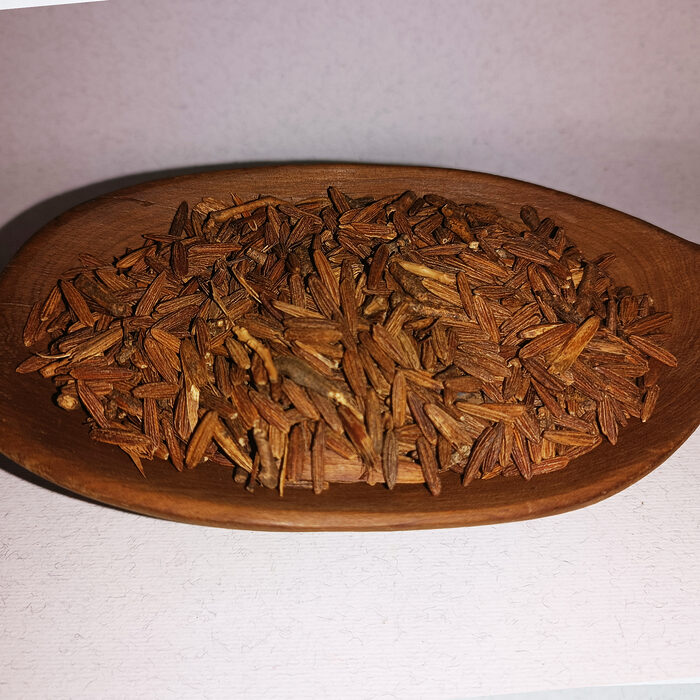 Dried brown Lissan Ettir bird's tongue herb pieces displayed on a wooden oval serving board against a light background - Variation