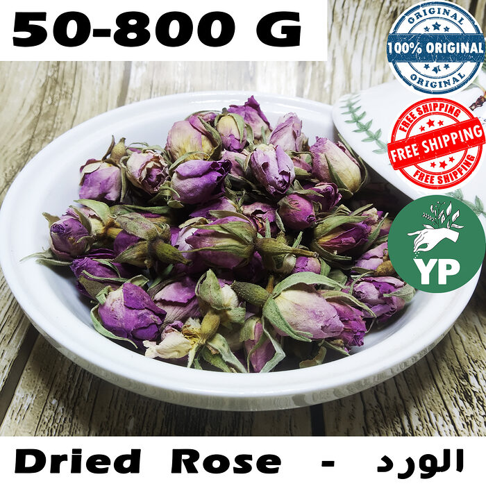 Whole dried purple-pink rose buds piled in a white ceramic bowl on a rustic wooden surface