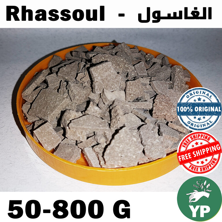 Natural Moroccan Rhassoul clay chunks displayed in a yellow bowl, showing the authentic grey-brown mineral clay pieces as mined from the Atlas Mountains