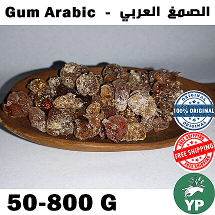 Amber and reddish-brown crystalline Gum Arabic resin pieces piled on a wooden oval dish against a light grey background