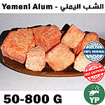Several chunks of reddish-orange Yemeni alum stone arranged on a wooden board, showing their raw crystalline texture and natural terracotta color