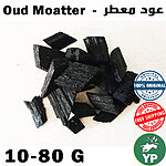 Dark black aromatic oud moatter bakhoor incense wood chips piled on a white background
